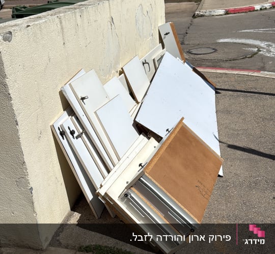 דלתות ארונות מונחות על המדרכה ליד בניין
